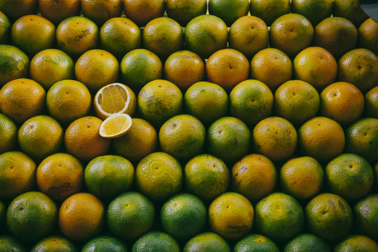 Laranjas organizadas em fileiras em uma feira, imagem usada para demonstrar tratamento de cor