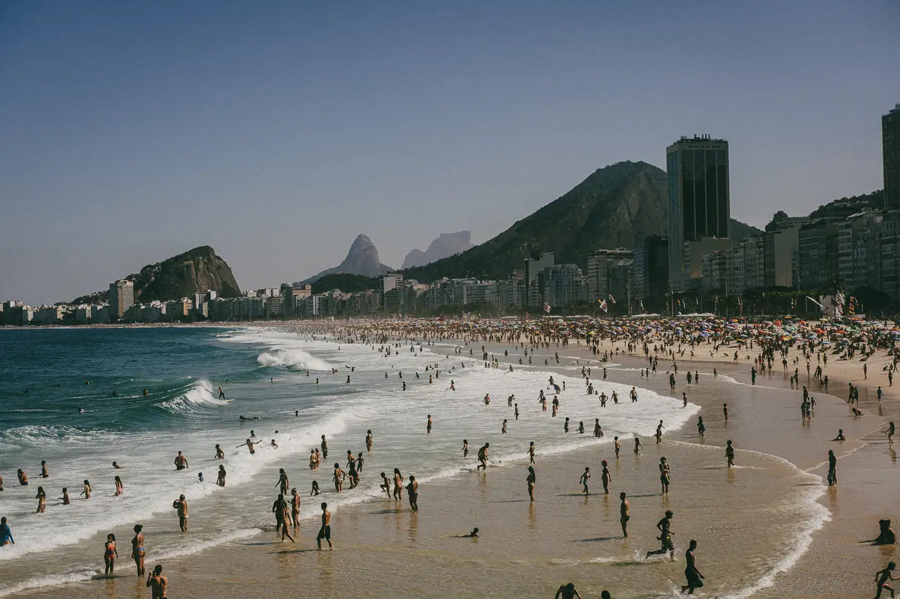 Vista ampla de praia lotada no Rio de Janeiro