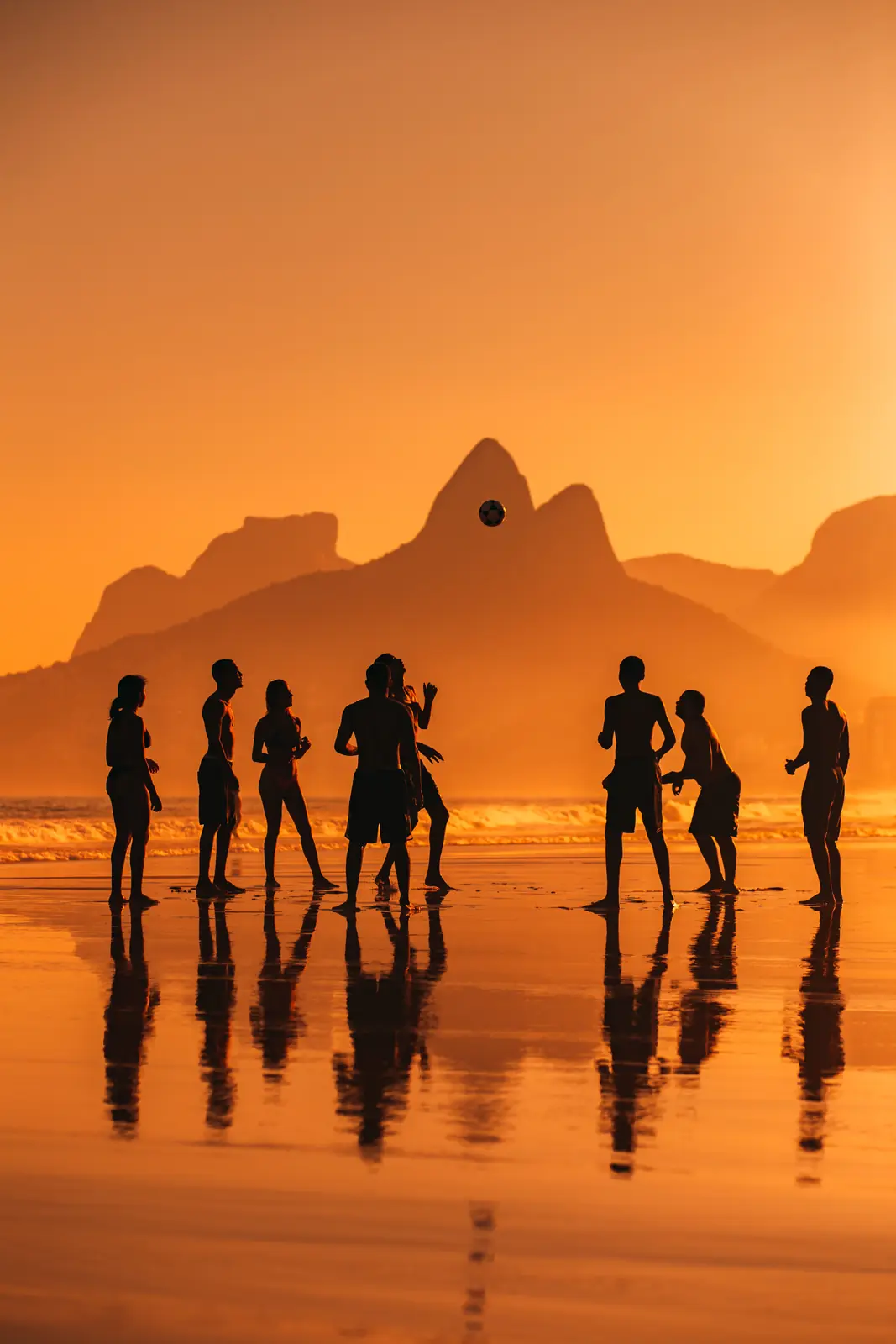 Roda de altinha em silhueta na praia de Ipanema ao pôr do sol
