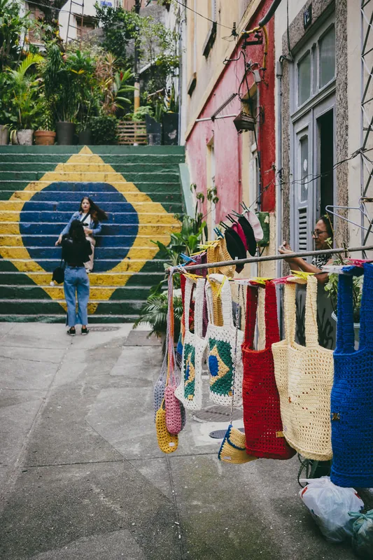 Bolsas de crochê penduradas em um varal na rua.